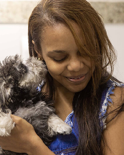 Cachorro feliz no colo de sua dona